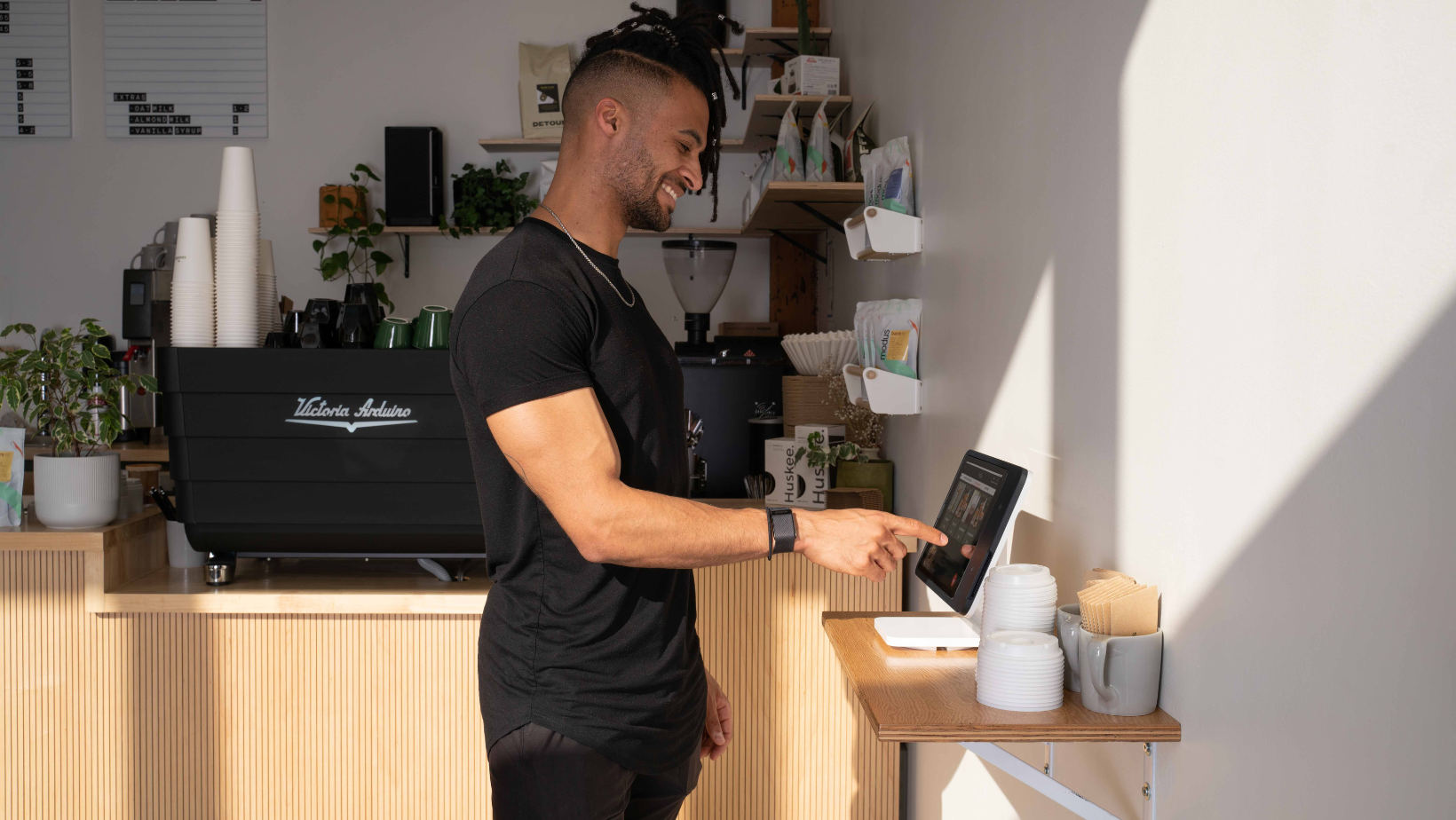 Coffee shop customer ordering on self-serve kiosk. 